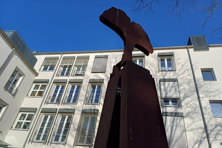René-Krönert-Gedenkstätte, Stele mit Ginkoblatt aus Cortenstahl, im Hintergrund das Gebäude des ASB Wohnzentrums